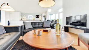 A modern living room with a leather sofa, a wooden coffee table, and a TV. - Awesome home in Augustenborg with WiFi (Augustenborg)