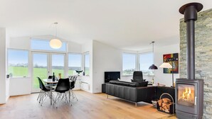 A spacious living room with a large fireplace, a dining area with a table and chairs, and a sofa. - Awesome home in Augustenborg with WiFi (Augustenborg)