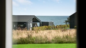 En kustutsikt med en byggnad som är märkt med siffran ’62’ och en vattenyta i bakgrunden.
