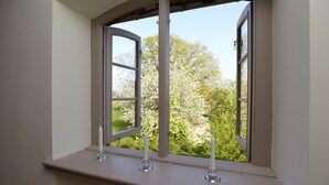 A room with a window overlooking a garden.