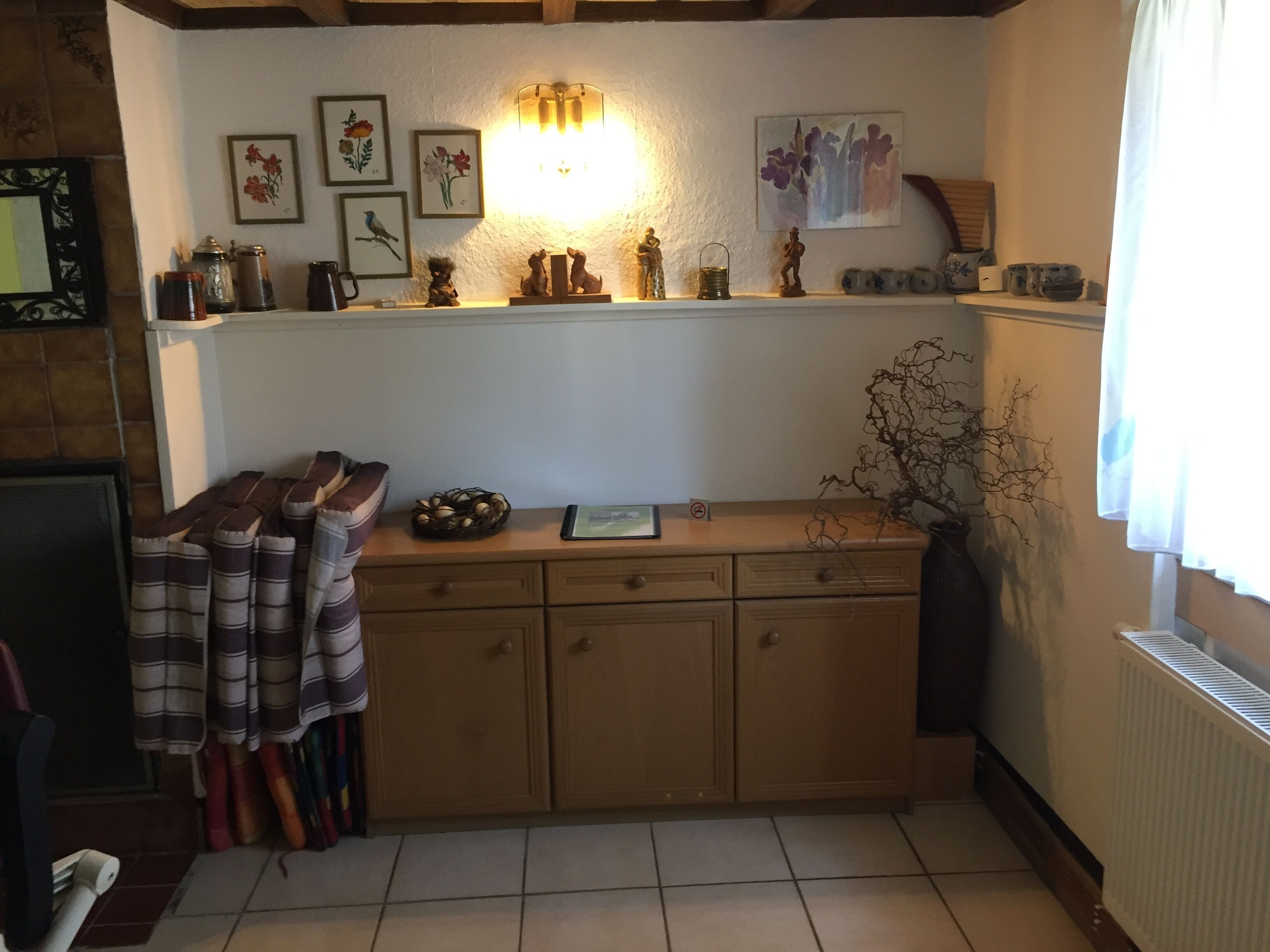 Eine gemütliche Küche mit einem Holzkabinett, einem Kamin und verschiedenen Küchenutensilien auf der Arbeitsplatte.