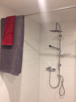 Bathtub, hair dryer, towels, toilet paper