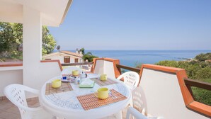 A round table with chairs on a balcony overlooking a coastal view. - 2 bedroom nice apartment in Joppolo VV (Joppolo VV)