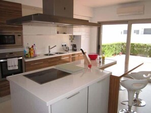 A modern kitchen with a built-in oven, microwave, and a large window providing a view of the outdoors.