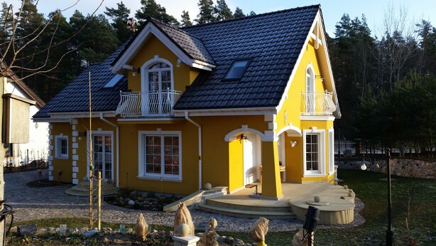 A yellow house with a dark roof, white trim, and a small balcony. - Small yellow villa in Masuria (apartment WEST in the attic) (Swieta Lipka,)