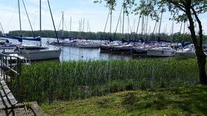 A marina with several boats docked, surrounded by greenery and trees. - Small yellow villa in Masuria (apartment WEST in the attic) (Swieta Lipka,)