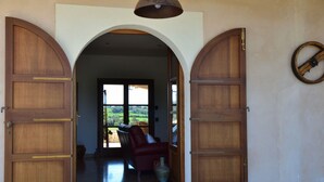 Una puerta con dos grandes puertas de madera, un tapete y una silla en el interior.