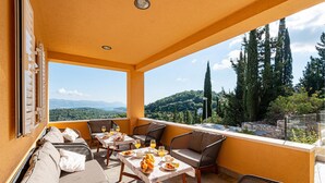 Un balcón con una mesa dispuesta para el desayuno, con vistas a un paisaje montañoso.