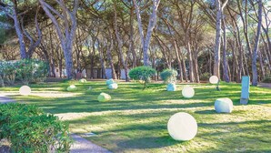 Ein Park mit großen, kugelförmigen Skulpturen, einem Weg und Bäumen.