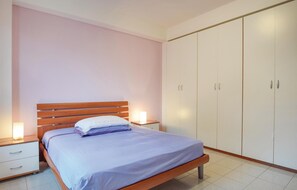 Cozy retreat with a single bed, nightstand, and spacious wardrobe.
