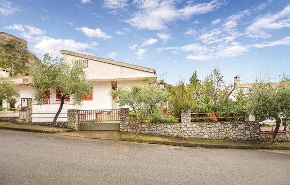 Situated in a tranquil residential setting, this property features a garden surrounded by a stone wall and offers easy access to the adjacent road.
