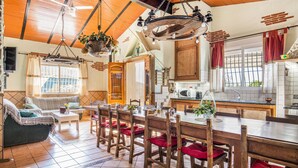 A cozy living room with a sofa, a dining table with chairs, and a kitchen area with a sink and stove. - Lovely home in Tallante (Tallante)