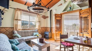 A cozy living room with a sofa, a table, and a wooden door with a sign reading "SALIDA". - Lovely home in Tallante (Tallante)