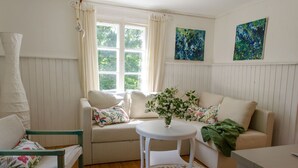 Ett mysigt rum med en soffa, ett litet bord och en stol.