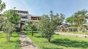 Una zona residenziale con un vialetto in pietra che conduce a una moderna casa a due piani con balconi.