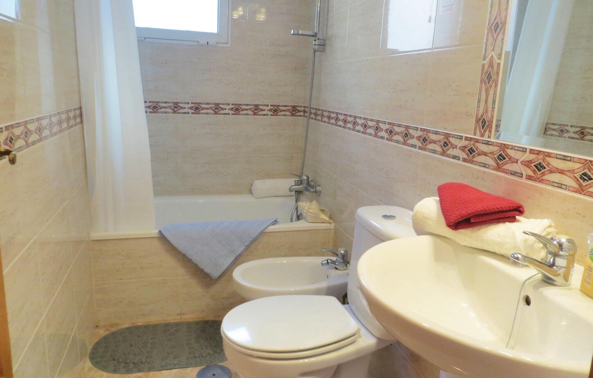 A bathroom with a bathtub, toilet, bidet, and sink.