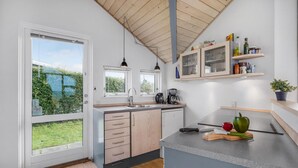 Eine moderne Küche mit großem Fenster, Holzboden und eingebauten Schränken.