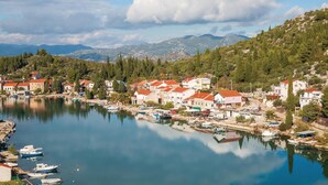 A coastal town with houses along the waterfront, boats docked, and mountains in the background. - Gorgeous apartment in Blace with WiFi (Blace)