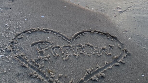 A beach with a heart drawn in the sand and the sun setting in the background. - small cozy apartment in a very quiet location (Prerow)