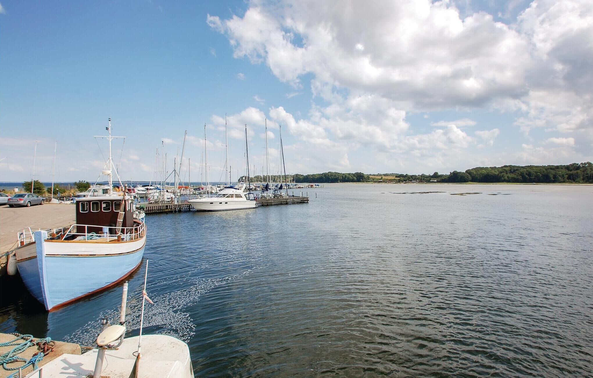 Een jachthaven met boten afgemeerd, kalm water en een heldere lucht.