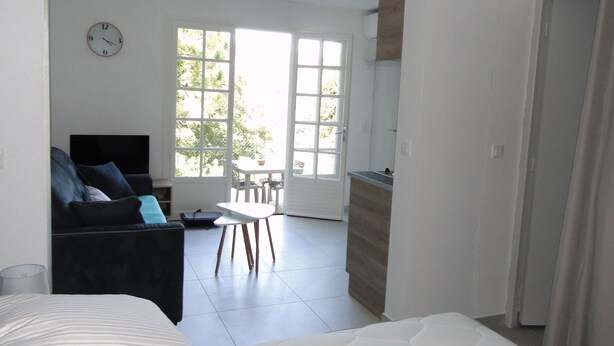 A modern hotel room with a bed, a sofa, a dining table, and a kitchen area. - LAST MINUTE Studio N ° 5 BC (Cavalaire-sur-Mer)