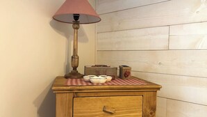 A wooden cabinet with a lamp, a checkered tablecloth, and kitchen items. - Centre Cauterets, appartement 72m2 pr 7 personnes (Cauterets)