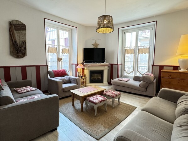 A living room with a fireplace, two sofas, a coffee table, and a television.