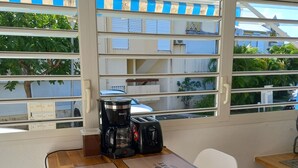 A small kitchenette with a coffee maker, a toaster, and a window with blinds. - Studio Oncle Sam: pool and beach access. Ideal for vacations or weekends for two (Le Gosier)