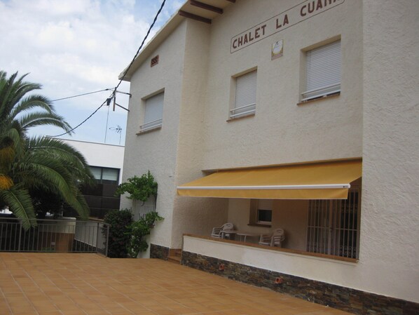 Un bâtiment appelé « CHALET LA CUAVO », doté d’un patio carrelé, d’un espace extérieur aménagé pour s’asseoir et d’un palmier.