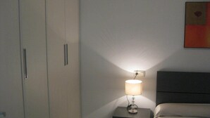 Una camera da letto con un letto, un comodino con una lampada e un armadio.