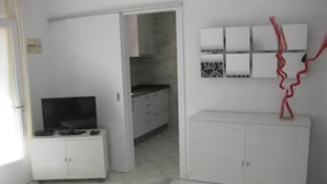 Una cucina moderna con mobili bianchi, un tavolo in vetro e un oggetto decorativo sopra il tavolo.