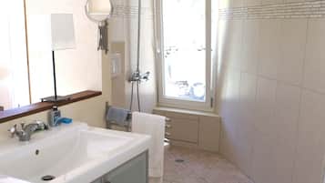 Een douche, een haardroger, handdoeken, toiletpapier