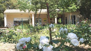 A building with a tiled roof and a garden with white roses. - Quiet cottage near Carcassonne pool (Ventenac-Cabardès)