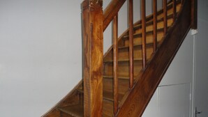 A wooden staircase with a handrail and a white door at the bottom. - Apartment hyper center of Saint Omer (Saint-Omer)