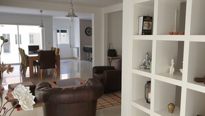 Un salón moderno con sofá, una mesa de centro y una estantería blanca con adornos.