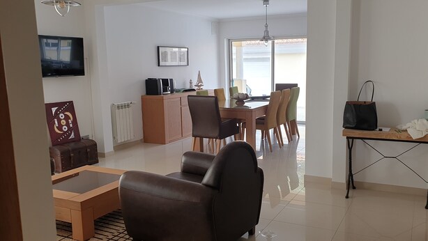 Una sala de estar moderna con un sofá, una mesa de centro y un comedor con sillas y una mesa.