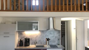 A compact kitchen with a coffee maker, sink, and utensils on the counter. - Spacious and pleasant T3 with pool near beach, port, leisure island  (Agde)