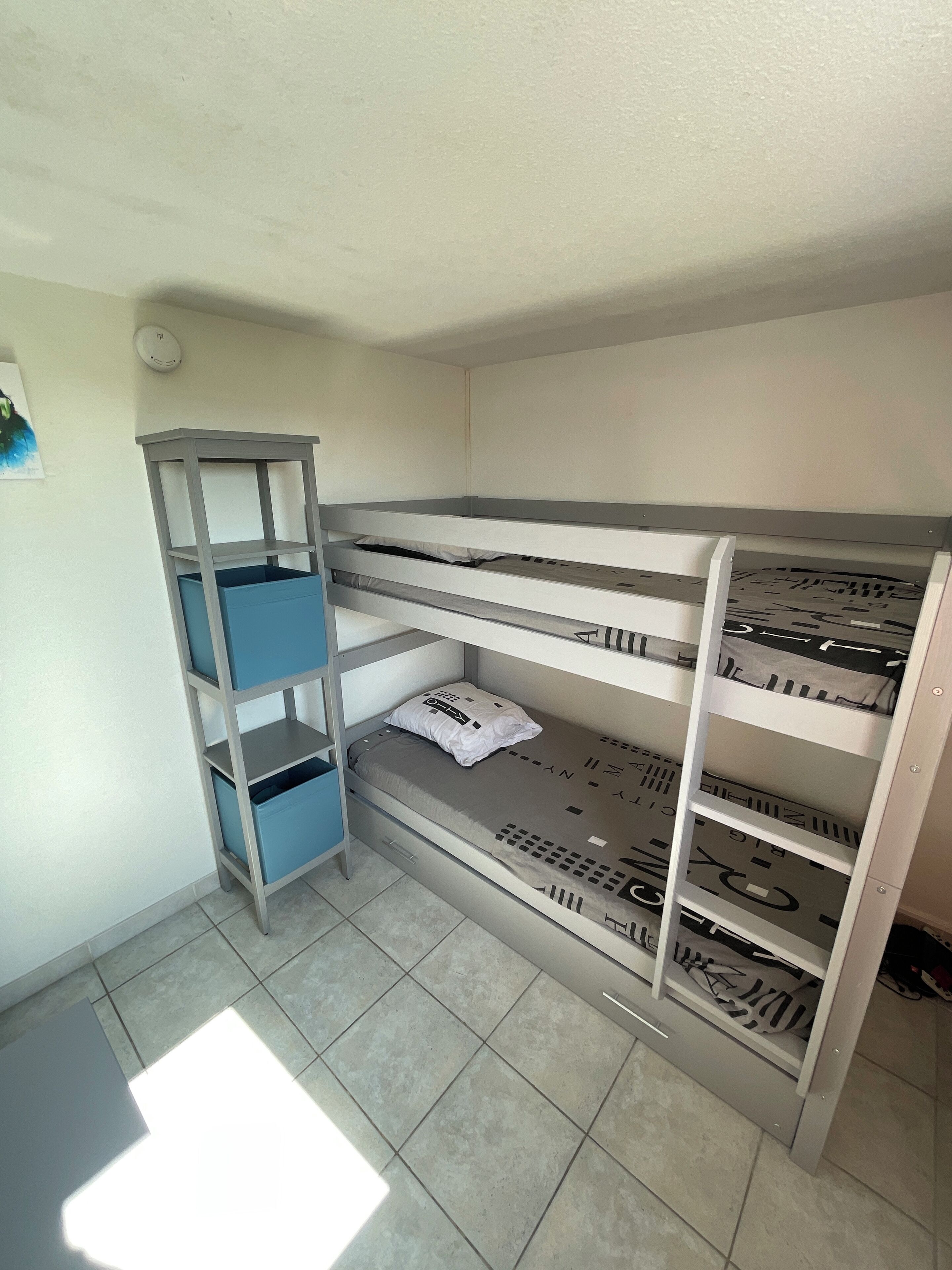 Un letto a castello con cassettiere e scaffalature.
