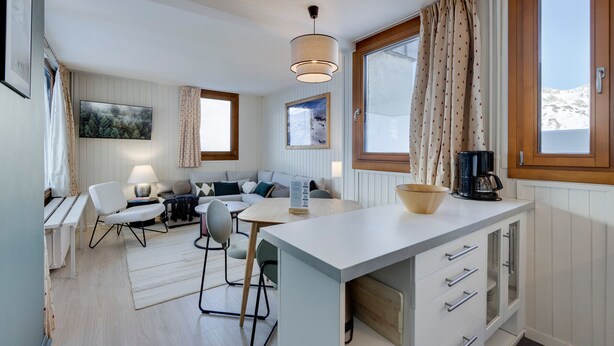 A modern kitchen with a dining area, wooden cabinets, and a view of the outdoors. - Tignes Val Claret: 2-Room Apt, Sleeps 4, Renovated & Near Slopes (Tignes)