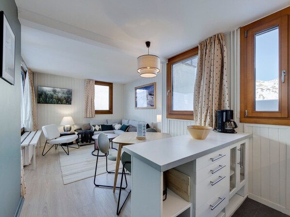 Eine moderne Küche mit Essbereich, Holzschränken und Blick ins Freie.