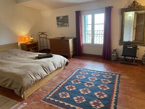 Um quarto com cama, cômoda, penteadeira, espelho e tapete.