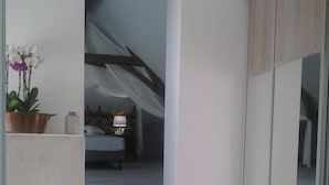 Un escalier moderne menant à une chambre à coucher équipée d’un lit et d’une table de chevet.