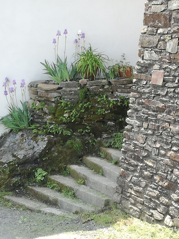Una escalera de piedra con peldaños que suben hacia una pared.