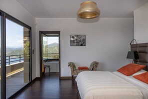 A bedroom with a bed, a chair, a table, a picture on the wall, and a balcony with a view. - Villa VERGHIA- 6 bedrooms, sea view, swimming pool (Coti-Chiavari)
