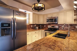 Enjoy cooking in this well-equipped kitchen with a gas stove, microwave, and water dispenser.