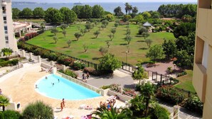 Un complexe hôtelier doté d’une piscine, d’une pelouse bien entretenue et offrant une vue sur la mer.