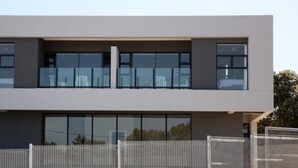 A modern two-story building with large windows and a flat roof.