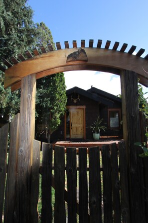 A wooden gate with a wooden archway leading to a house with a wooden door and a window. - Walk to downtown and Amphitheater (Bend)