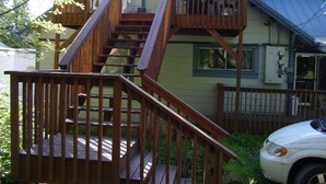 A two-story house with a wooden staircase leading to a balcony.