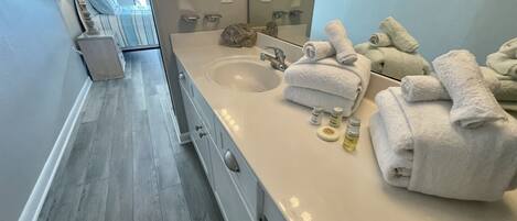 Un baño moderno con lavamanos doble, un espejo grande y toallas ordenadas.